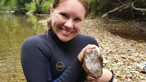 Photo of Sarah Tomke and hellbender salamander